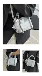 Détail macro du sac cabas en cuir gris clair brillant avec poignées tressées et nœud dentelle