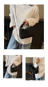 Détails du sac à main noir plissé avec bandoulière en chaîne argentée et doubles pompons