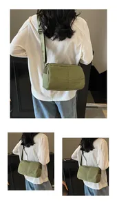 Detail of adjustable strap and olive green water-resistant nylon fabric on shoulder bag