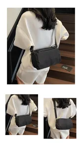 Detail of black waterproof nylon crossbody bag with adjustable strap and side drawstring