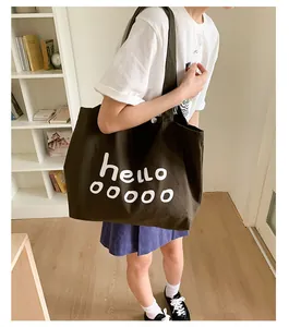 Detailed view of deep olive green canvas tote with white hello print on a shoulder bag