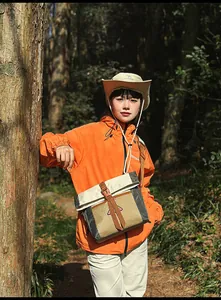 Detailaufnahme der orangefarbenen Windjacke mit multifunktionaler Patchwork-Umhängetasche