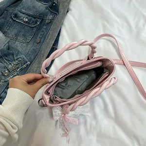Sac seau tendance rose avec poignées tressées, nœud en dentelle et vue intérieure