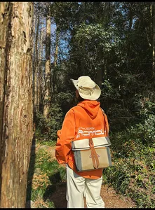 Outdoor-Umhängetasche in Grau und Beige mit orangefarbener Schnalle im Wald