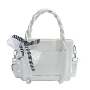 Sac seau en cuir blanc avec poignée tressée et nœud décoratif à carreaux noirs et blancs
