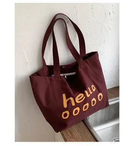 Detail of dark burgundy canvas tote featuring magnetic closure and inner zipper pocket