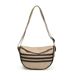 Khaki canvas crescent bag with three black stripes and adjustable crossbody strap