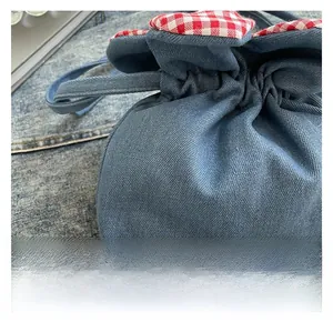 Nahaufnahme des blauen Denim-Beutels mit rot-weißem Karo-Stoffbesatz am Rand