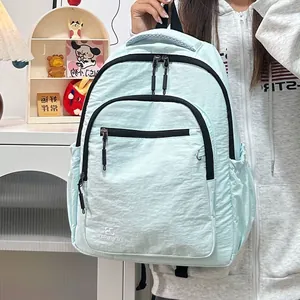 Detailopname van de lichtblauwe nylon rugzak met meerdere vakken en zwarte ritsaccenten