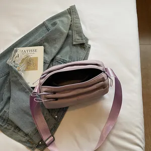 Light purple multi-pocket nylon crossbody bag on a minimalist lifestyle background