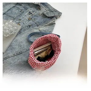 Innenansicht der blauen Denim-Tasche mit rot-weißem Karofutter und Stauraumdetails