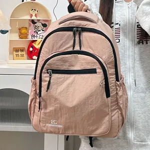 Detail van roze nylon rugzak met kreukeltextuur en meerdere functionele zakken