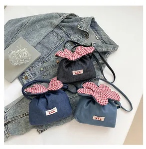 Detail der Jeans-Beuteltasche mit Erdbeer-Etikett und rotem Gingham-Kordelzug oben