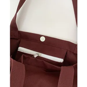 Canvas tote bag with magnetic snap closure and inner zipper pocket in deep red color