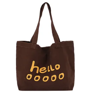 Brown canvas tote bag with yellow hello print lettering and large storage space