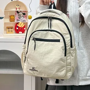 Detail van beige nylon rugzak met zwarte ritsen en handige zijvakken voor studenten