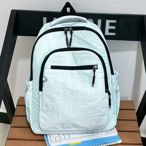 Detail van een licht mintgroene nylon rugzak met zwarte ritsen en zijvakken