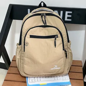 Khaki minimalistische nylon rugzak voor studenten en reizen op houten bank geplaatst