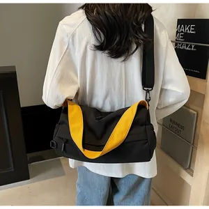 Detail of adjustable wide shoulder strap and black nylon fabric texture on crossbody bag