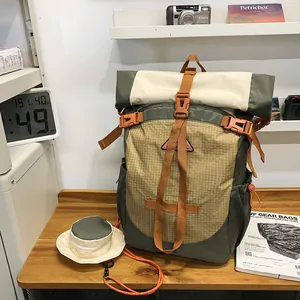 Outdoor-Rucksack mit Rolltop in Olivgrün und Creme, orangefarbene Riemen und Anhänger
