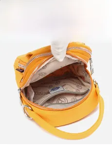 Detail showing the internal storage capacity and printed lining of the yellow crossbody bag