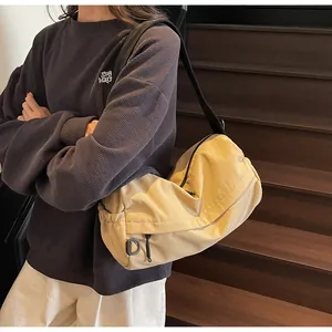 Detail of beige casual crossbody bag with black adjustable strap and soft fabric texture