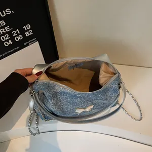Blue denim tote bag with silver butterfly metal decor and chain shoulder strap