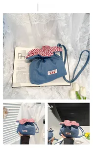 Detail der blauen Canvas-Beuteltasche mit Erdbeer-Aufnäher und rotem Karo-Volant