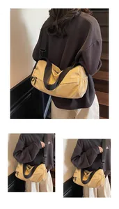 Detail of light yellow canvas crossbody bag with adjustable wide black strap on stairs
