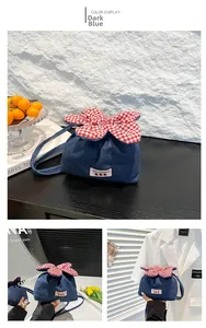 Detailansicht der dunkelblauen Denim-Tasche mit rot-karierter Blume und Erdbeer-Etikett