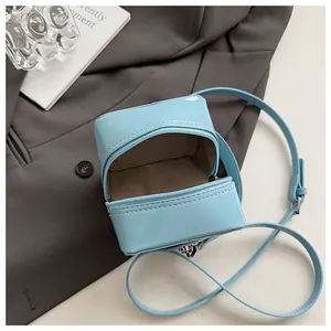 Macro shot of light blue patent leather bag showing brown lining and silver zipper detail