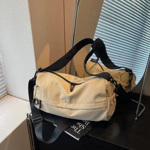 Chic beige nylon crossbody bag with adjustable wide strap shown in a mirrored lifestyle scene