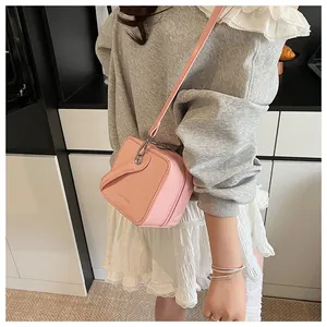Detailed view of pink glossy PU leather crossbody bag with metallic logo branding