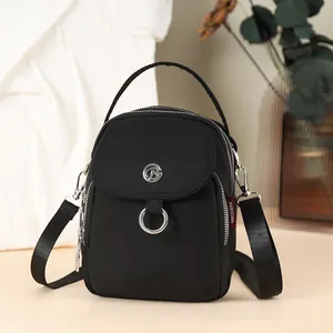 Minimalist black nylon crossbody bag with silver hardware and adjustable wide shoulder strap
