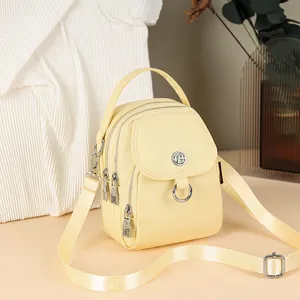 Minimalist cream yellow nylon crossbody bag with multi-layer zipper and metal rings