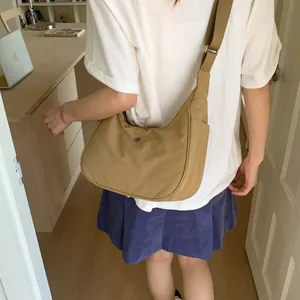 Détail du sac demi-lune en nylon kaki avec fermoir en métal et bandoulière réglable