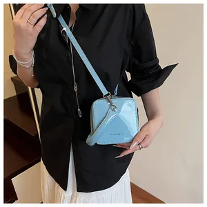 Detail of light blue patent leather mini bag with silver buckle and fashion text