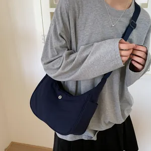 Détail du sac bandoulière en nylon bleu marine en forme de croissant avec sangle ajustable