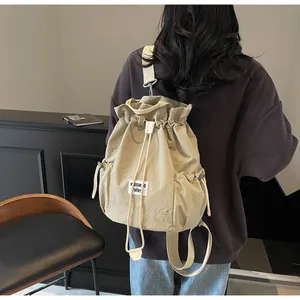 Detail view of khaki canvas drawstring backpack showing textured fabric and shoulder straps