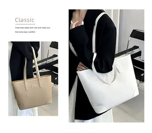 Detail of large litchi leather tote bags showing reinforced corners and long straps