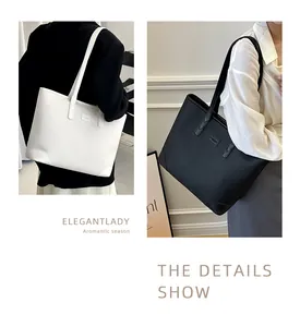 Detail of high-capacity tote bags showing white and black lychee grain leather texture