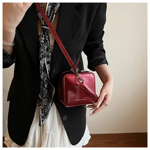 Detail of red patent leather box bag with Fashion & Bags text on a stylish outfit