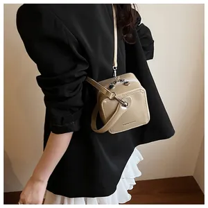 Detail of glossy box bag with heart-shaped zipper and delicate crossbody strap