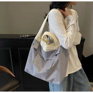 Dettaglio della borsa tote in tela a righe blu e bianche con spallacci rinforzati