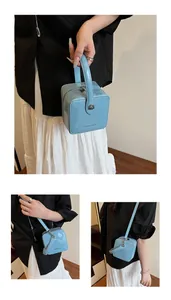 Detailed views of light blue patent leather box bag with silver heart charm and strap