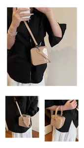 Detail of beige patent leather box bag featuring FASHION & BAGS text and crossbody strap