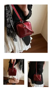 Close-up of bright red patent leather box bag with Fashion & Bags embossed metal logo