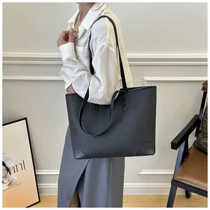 Detail view of black lychee grain tote bag with reinforced base corners and slim straps