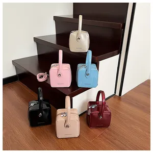 Showcase of six colorful glossy patent leather box bags with heart-shaped zipper details