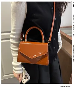 Détail du sac à main en cuir verni caramel avec fini brillant et détails dorés